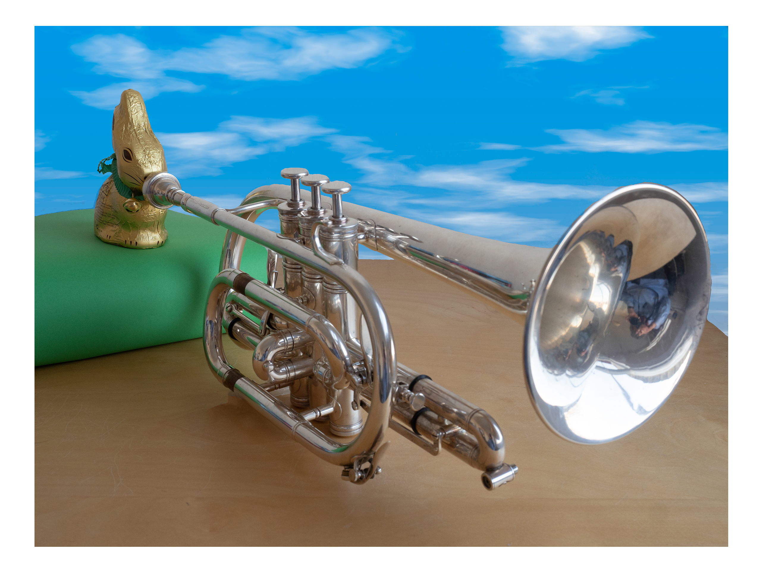 gold wrapped chocolate rabbit playing a cornet, wide shot with whole bunny and instrument